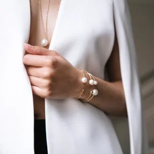 Eleganter Perlenschmuck mit Halskette und Armreifen, getragen zu einem minimalistischen Outfit