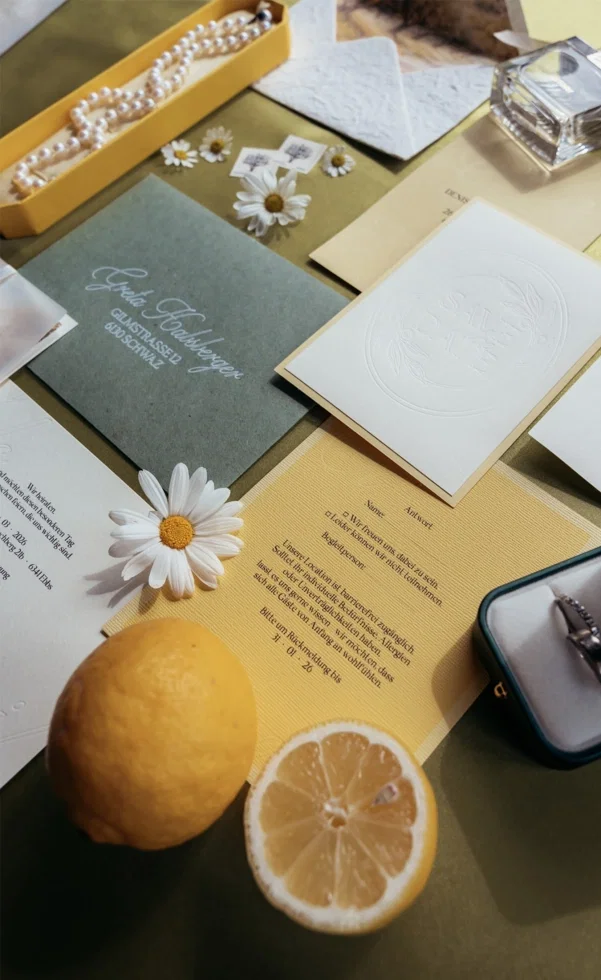 Hochzeits-Papeterie mit Zitronen-Motto: Einladungskarten, Umschläge und Details in Gelb- und Grüntönen, dekoriert mit Zitronen und Gänseblümchen