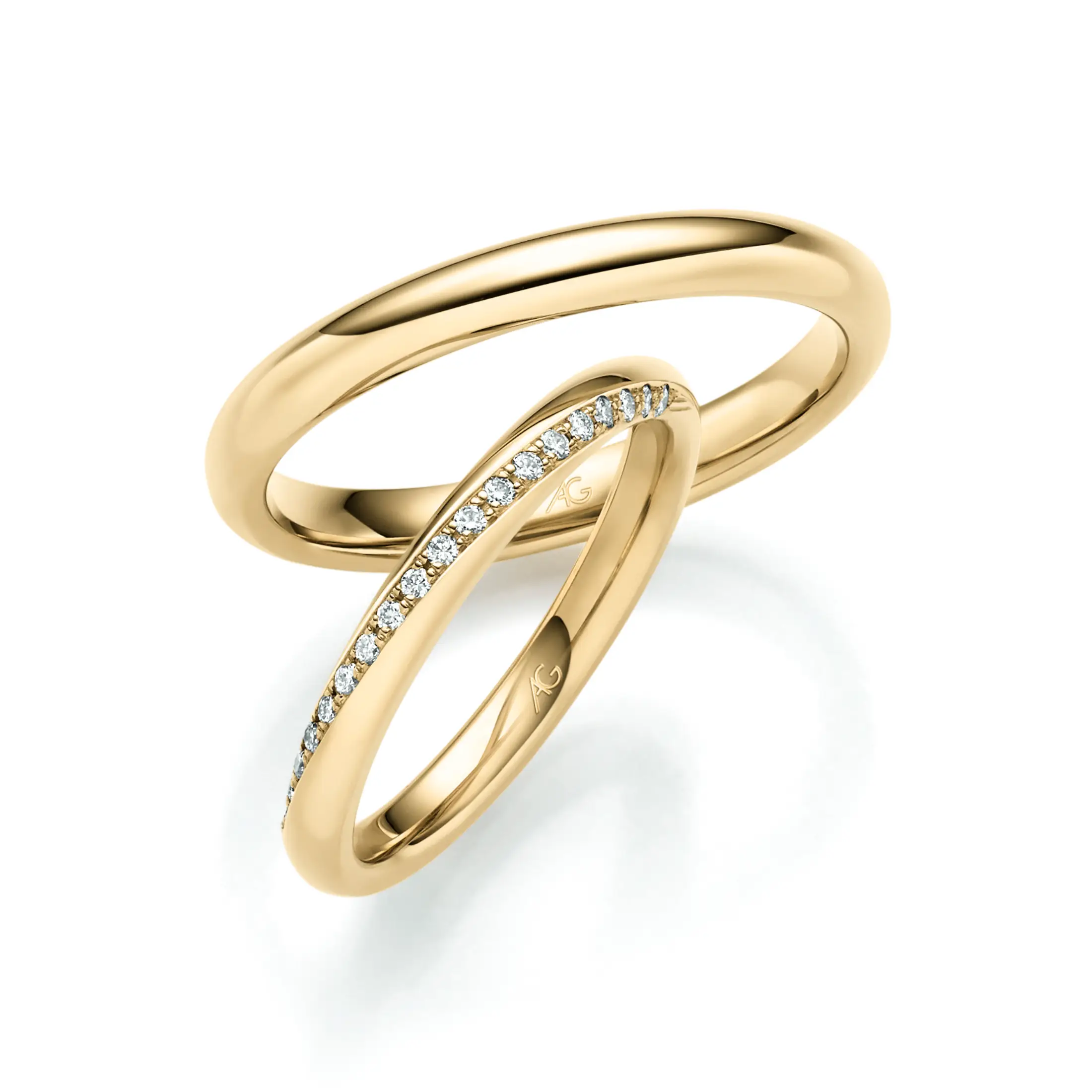 Schlichte Goldringe mit weicher Rundung und elegant geschwungenem Damenring mit Diamantbesatz.