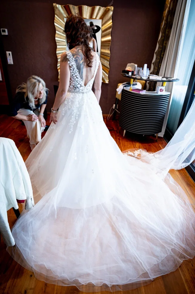 Braut in romantischem Tüllkleid mit tiefem Rückenausschnitt beim Getting Ready vor der Hochzeit.