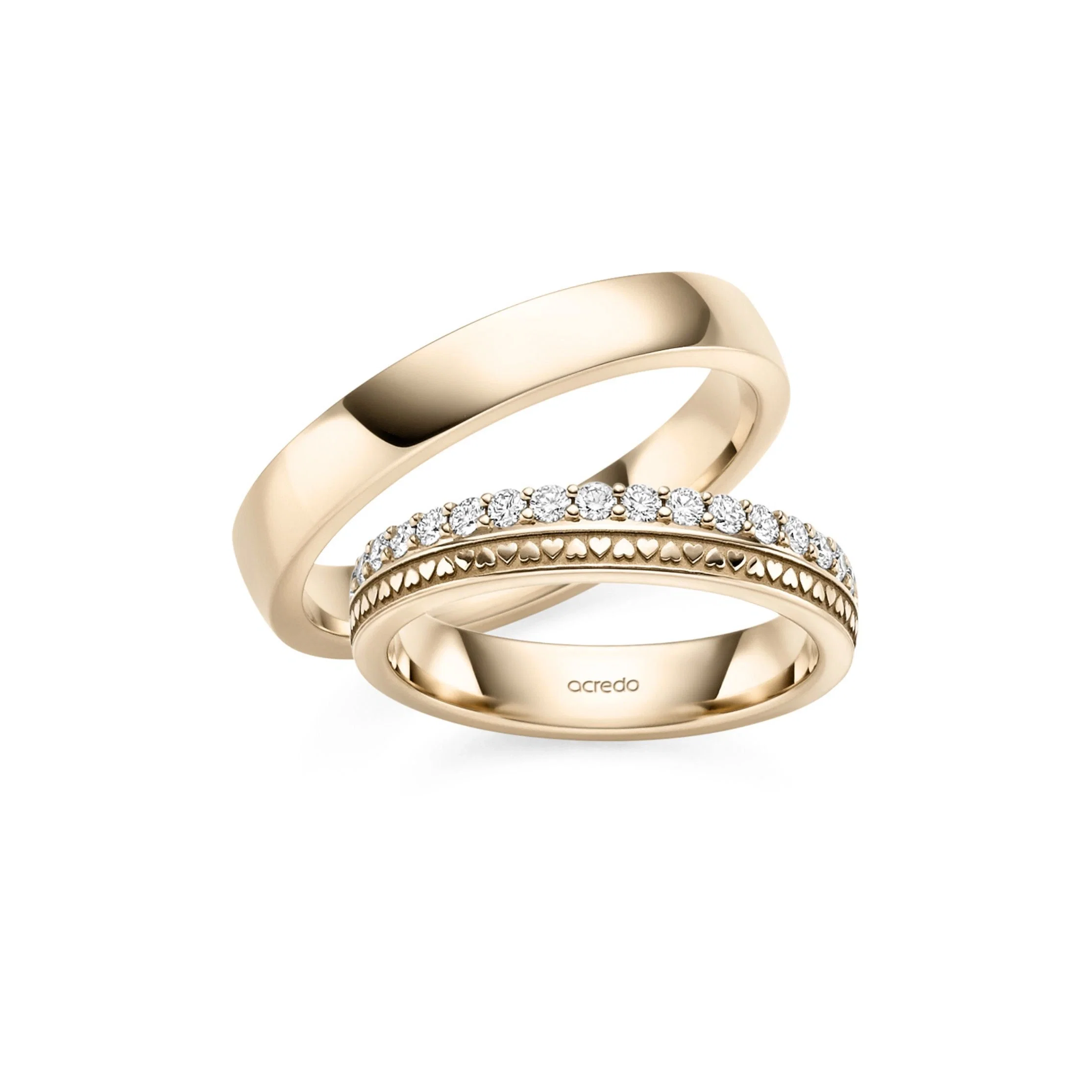 Elegante Trauringe aus Gelbgold mit glänzender Oberfläche und funkelnder Diamantreihe in Herzoptik.