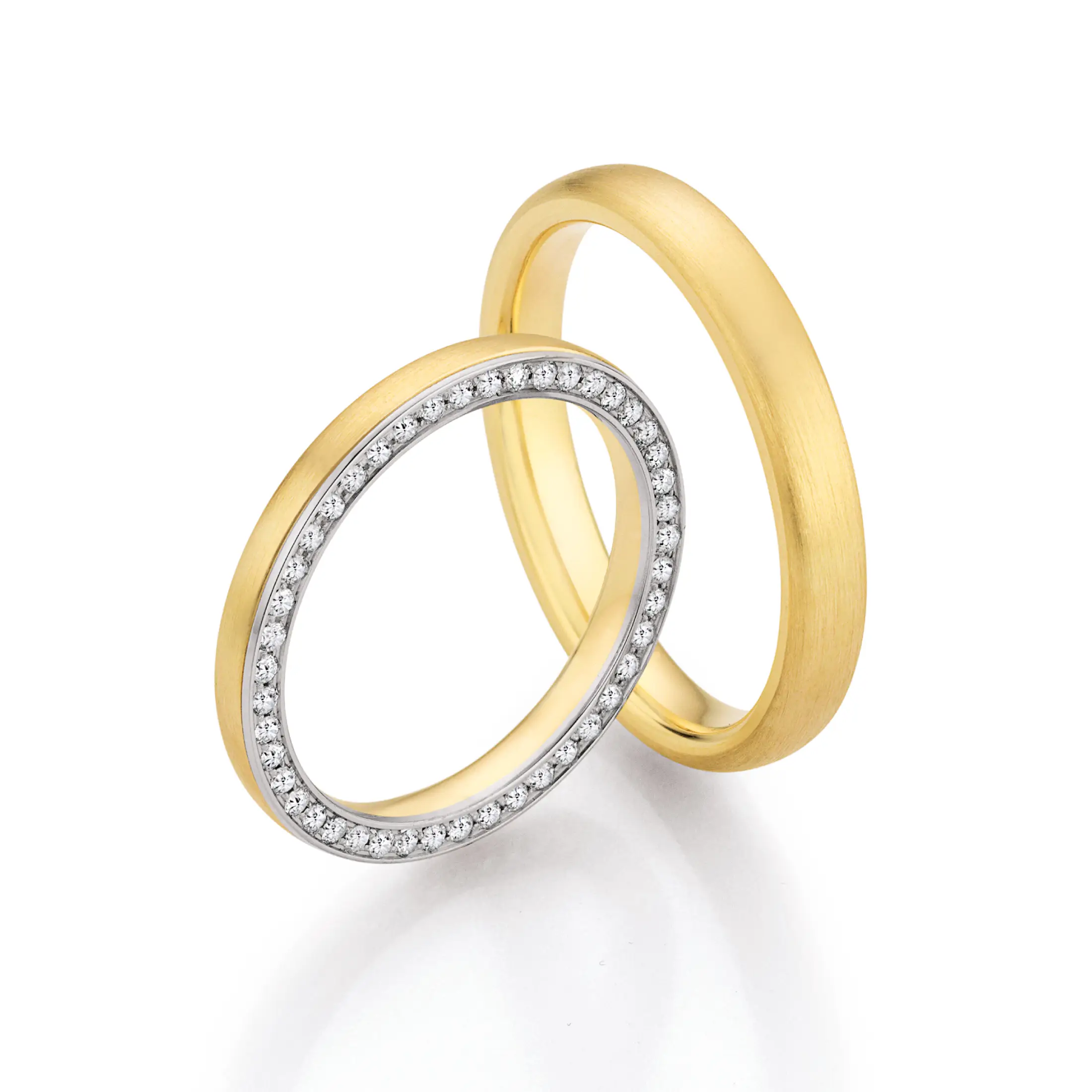 Klassische Eheringe aus Gelbgold mit mattierter Oberfläche und filigranem Memoire-Ring aus Weißgold und Diamanten.