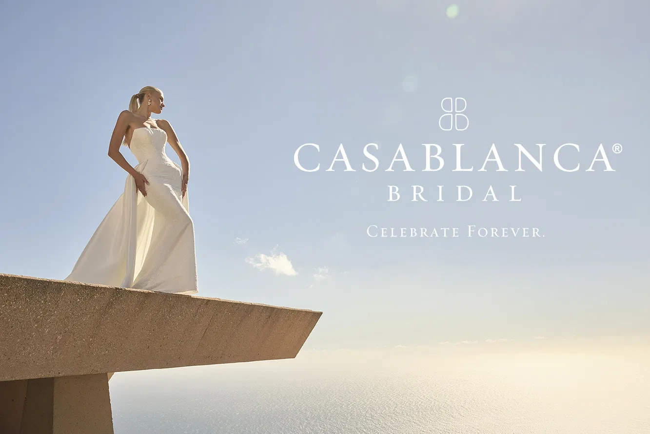 Banner Casablanca Bridal, eine Braut auf einem Vorsprung, im Hintergrund ein weicher Himmel